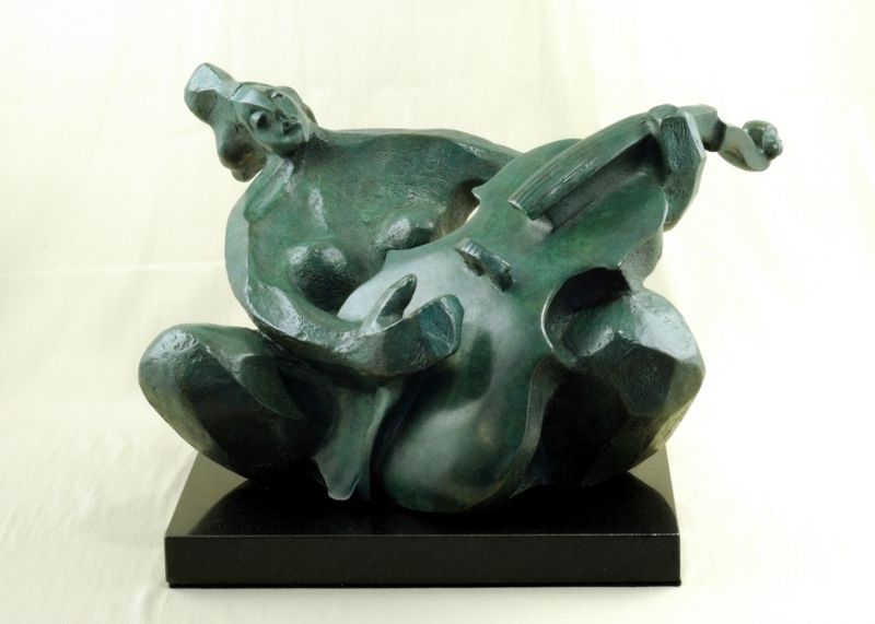 The Cello Player embraces her instrument as though it were a lover rather than a cello; it is wrapped sensuously around her sturdy, yet feminine body. Her face is completely relaxed as she looks to the sky.  Her spirit yearns to escape the confines of earth.  Sitting cross-legged and leaning slightly to the left, perhaps she is swaying to the music she hears.  The Cello Player’s light angelic demeanor is in sharp contrast with the sculpture itself, whose sheer mass dictates that it will forever be tethered to this world.